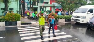 Babinsa bantu menyeberangkan jalan