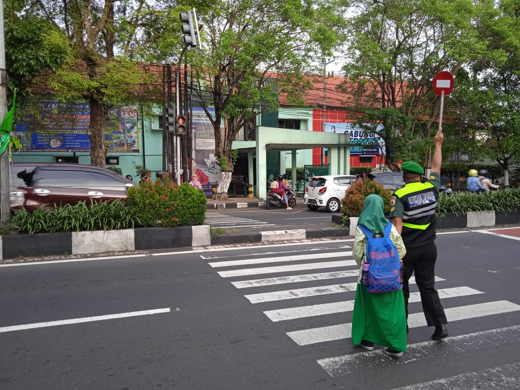 Babinsa Blimbing bantu menyeberangkan jalan